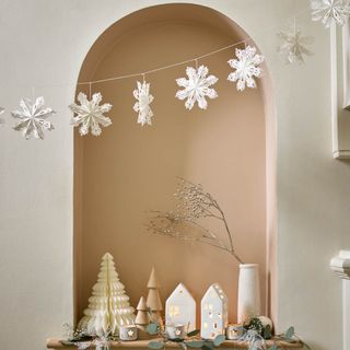 An arch with paper Christmas decorations and a garland