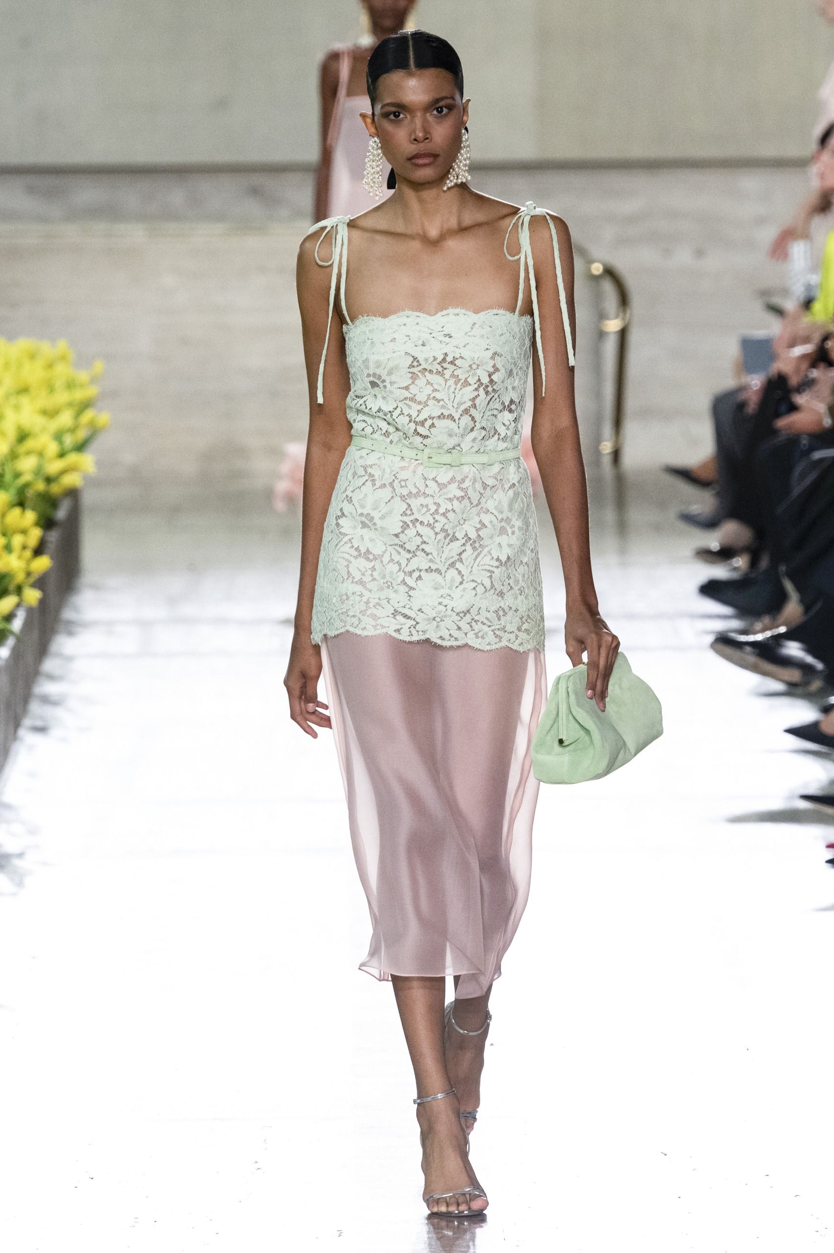 a model on a catwalk dressed in mint green clothes