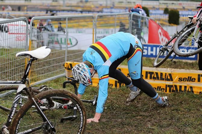 A Belgian rider goes down after crashing over a barrier