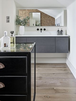 White bathroom with dark grey vanity and warm wooden flooring