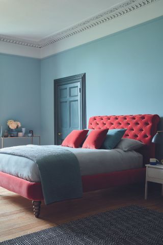 How to make a small bedroom look bigger in a turquoise scheme with pink velvet upholstered bed.