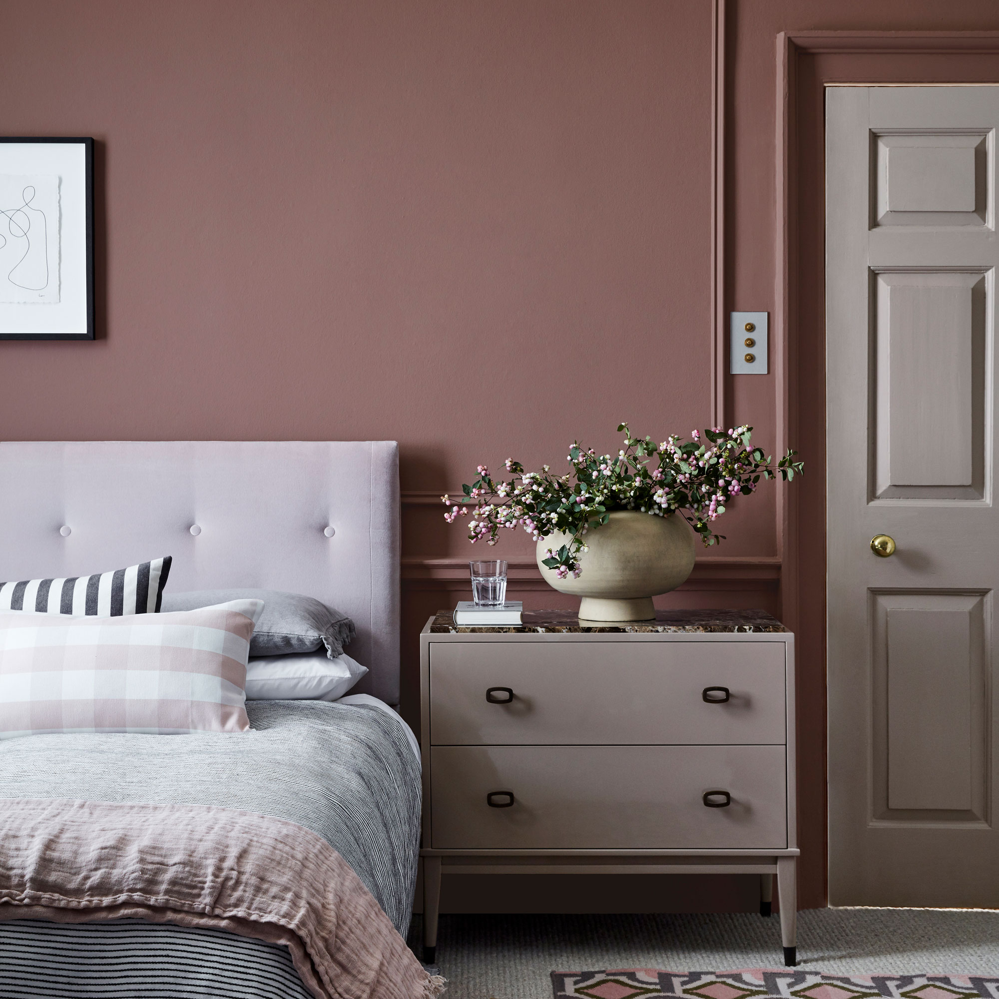 Mauve pink bedroom with pink headboard and pink side table