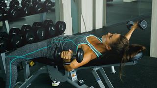 Woman performing chest flye with dumbbells