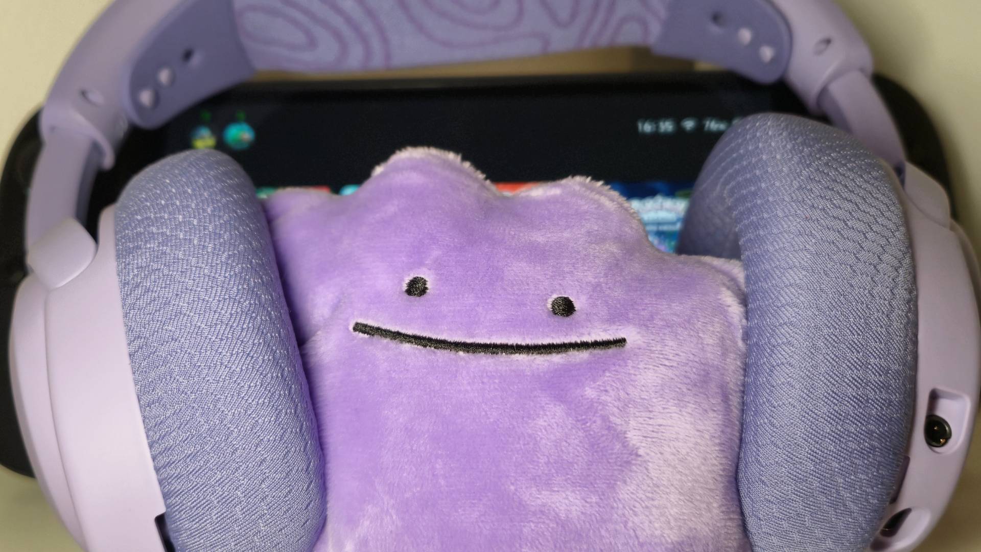 Photo of a Ditto plushie wearing the SteelSeries Arctis Nova 3 Wireless gaming headset.