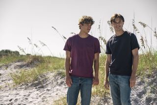 gavin casalengo as jeremiah and christopher briney as conrad, standing on a beach, in 'the summer i turned pretty' season 2