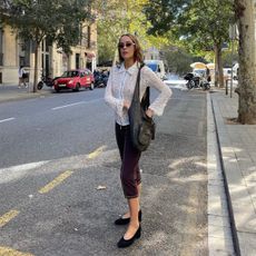 Helena Cuesta wearing capris and a zip-front top with sunglasses.