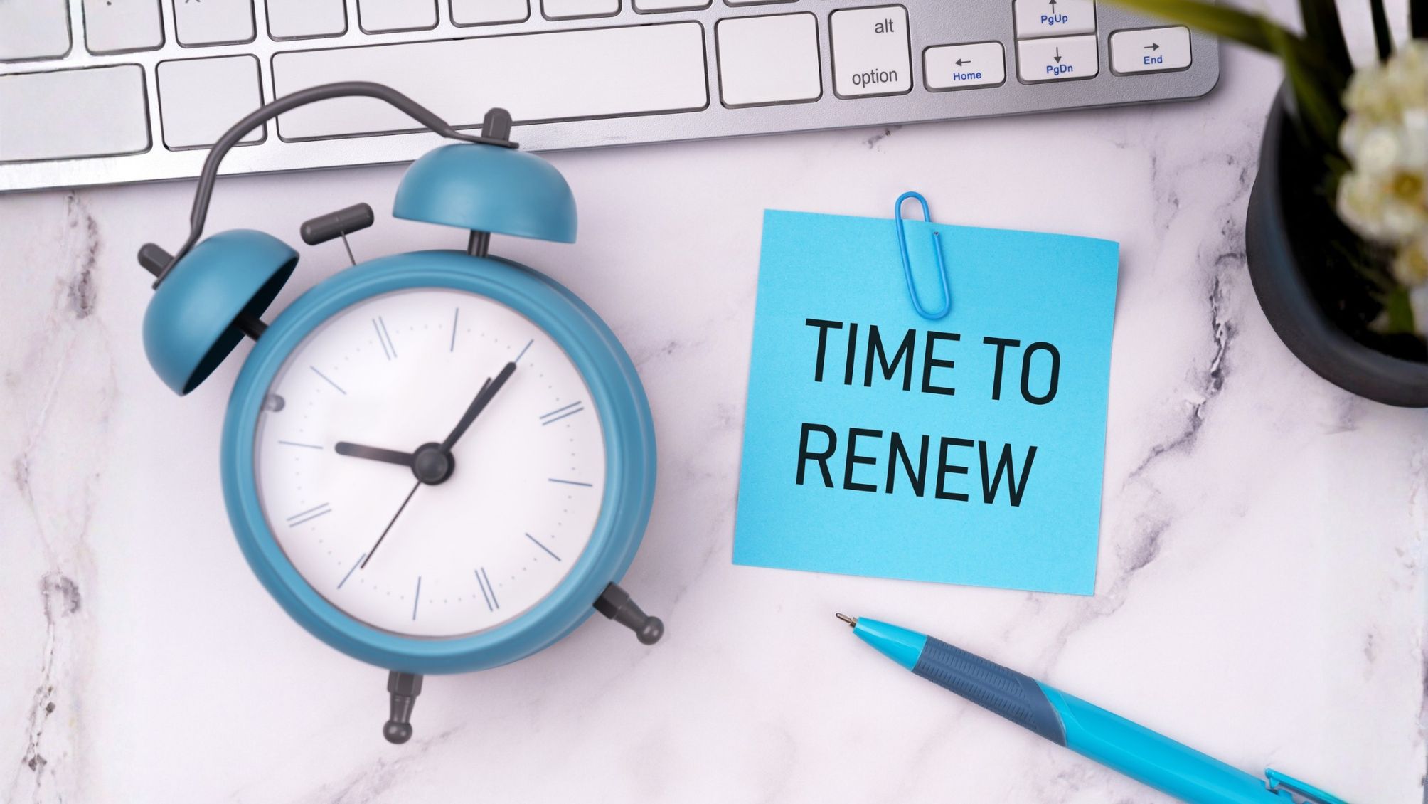 A clock on a desk next to a note that says Time To Renew 