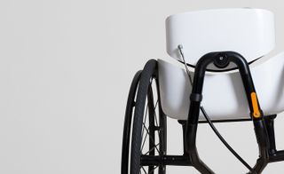 A detail of a modern wheelchair. It has a white seating.
