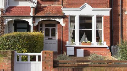 Front of modern red brick terraced home with white front door