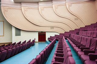 North Korea’s East Pyongyang Grand Theatre with scalloped peach-coloured walls, purple-upholstered seats and a bright-blue vinyl floor