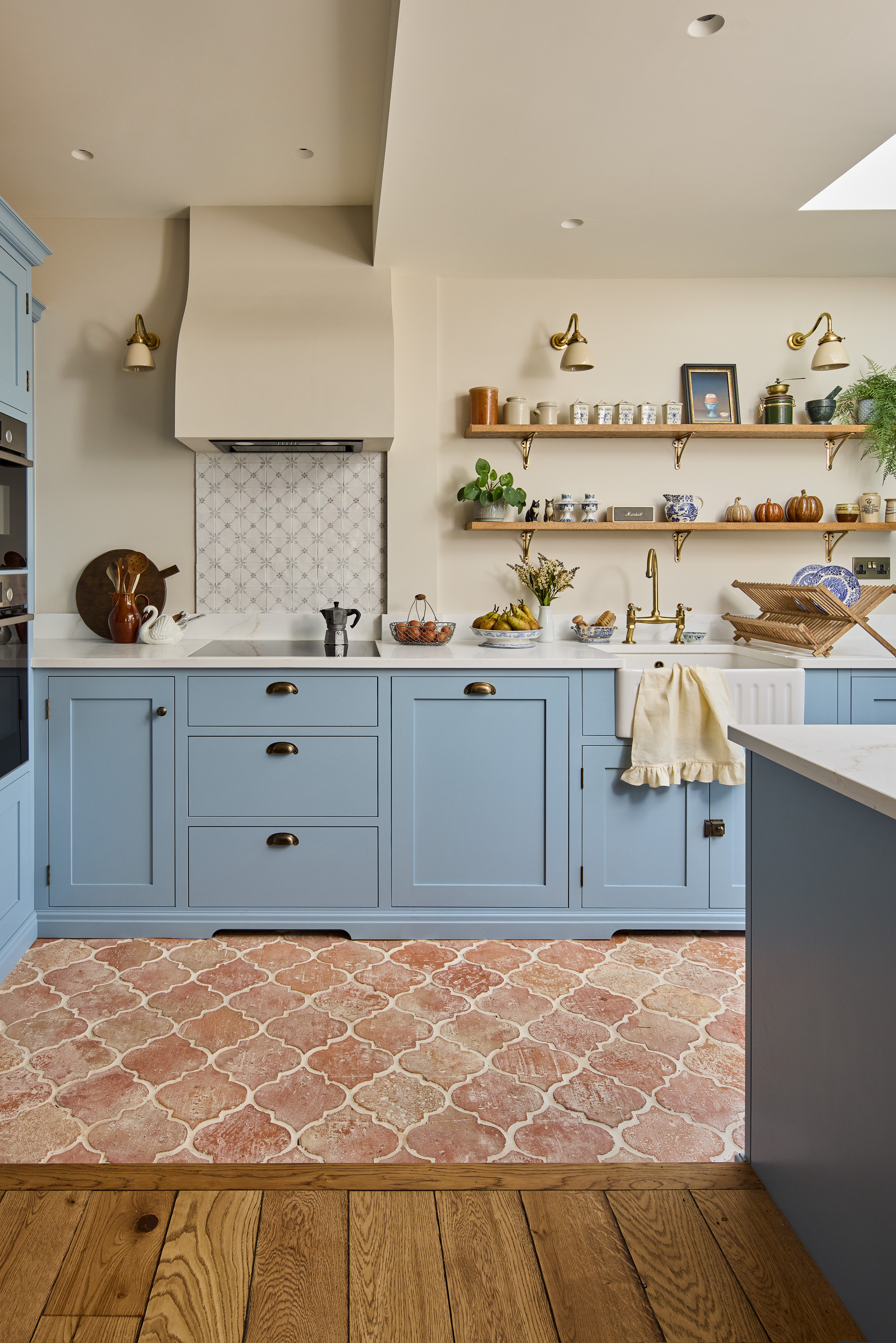 sky blue kitchen with terracotta tile floors and open shelves