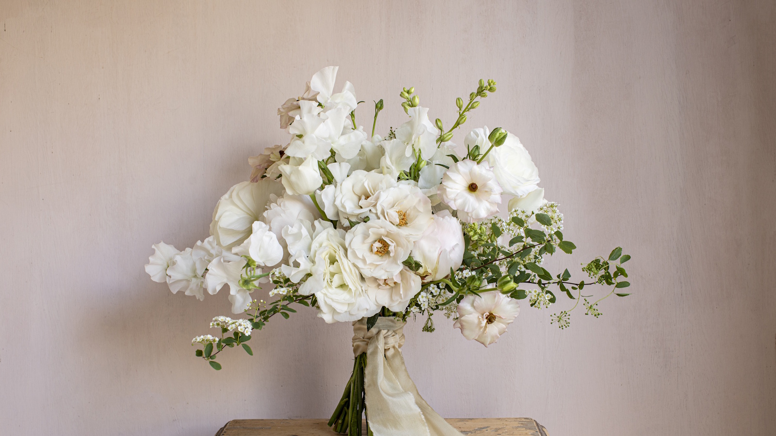 Bouquet of white flowers with spray roses, spirea, sweet peas and peonies