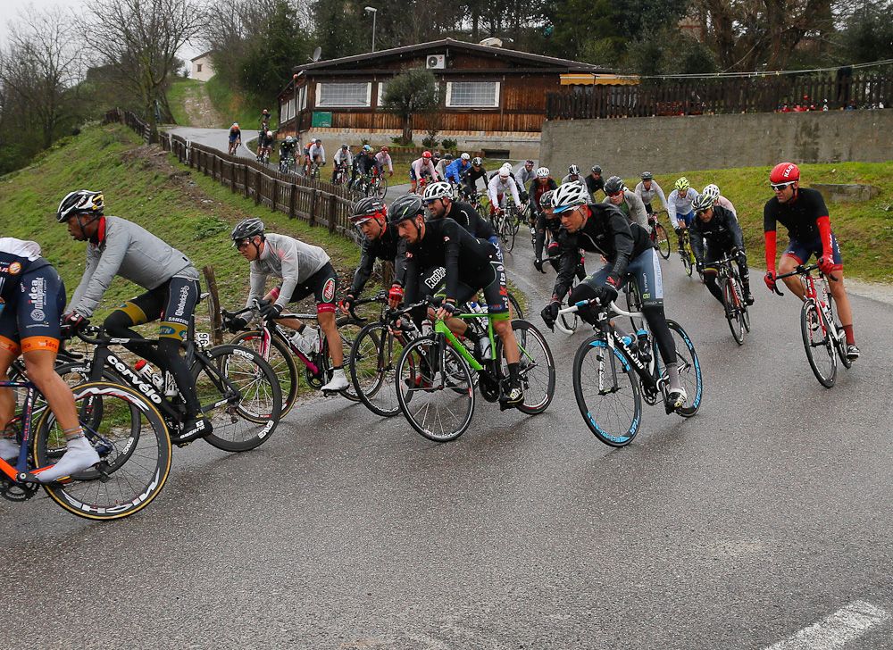The peloton negotiates a wet corner