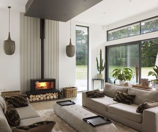 A living room with wood burning fireplace and light coloured furnishings