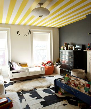 kids room with yellow stripped ceiling and woolen carpet