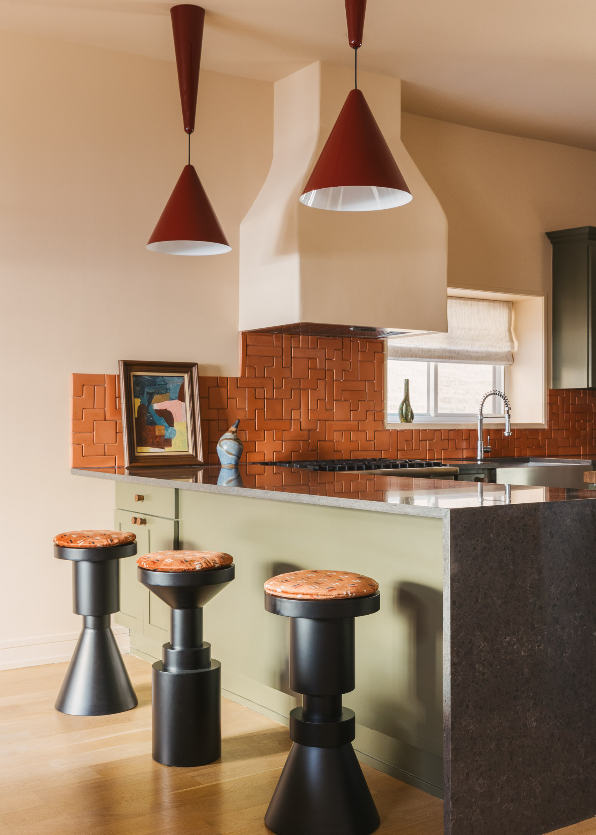 kitchen bar seating area with geometric bar stools and pendant lights