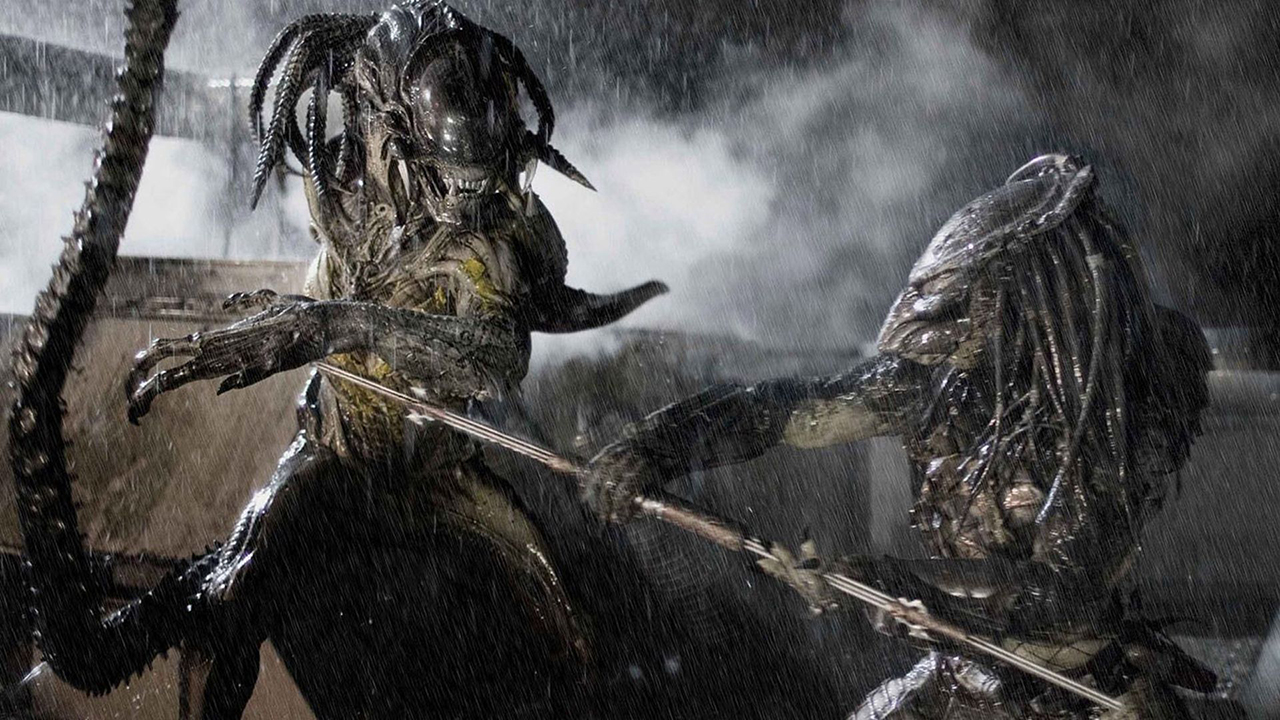 Still from the movie Aliens vs.  Predator: Requiem (AvPR).  Predator is jabbing a spear at a swiping Alien during a heavy rainstorm.
