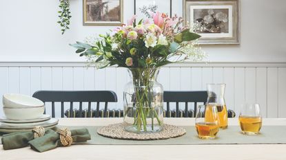 A vase of flowers in the centre of a dining table