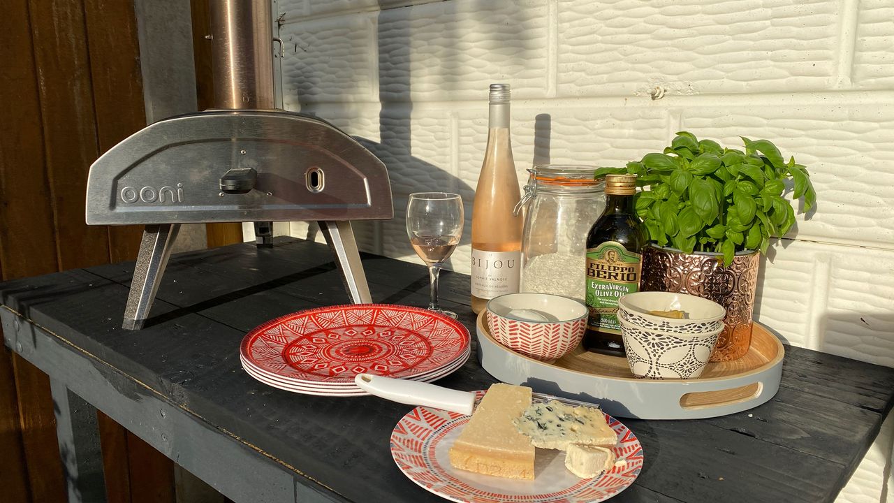 pizza oven on a table with toppings and wine