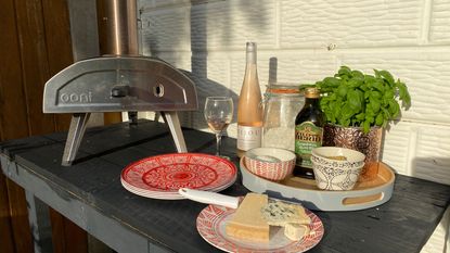 pizza oven on a table with toppings and wine