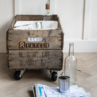 wooden bin storage with glass bottle and white wall