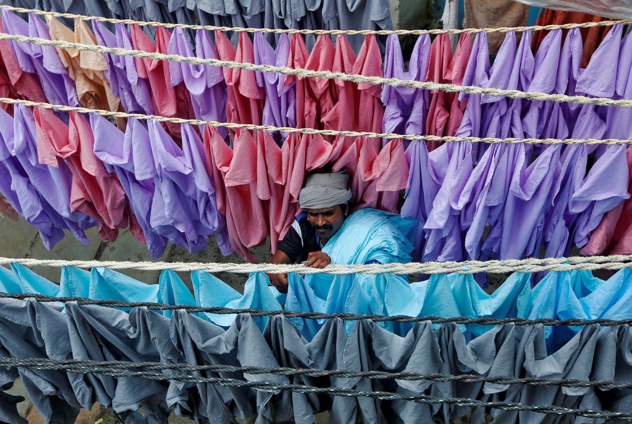 A man hangs shirts out to dry in an open-air laundry in Mumbai, India.