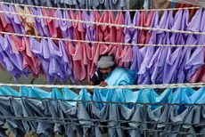 A man hangs shirts out to dry in an open-air laundry in Mumbai, India.