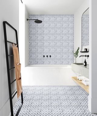 An example of small bathroom flooring ideas showing decorative blue and white floor and wall tiles in a bathroom