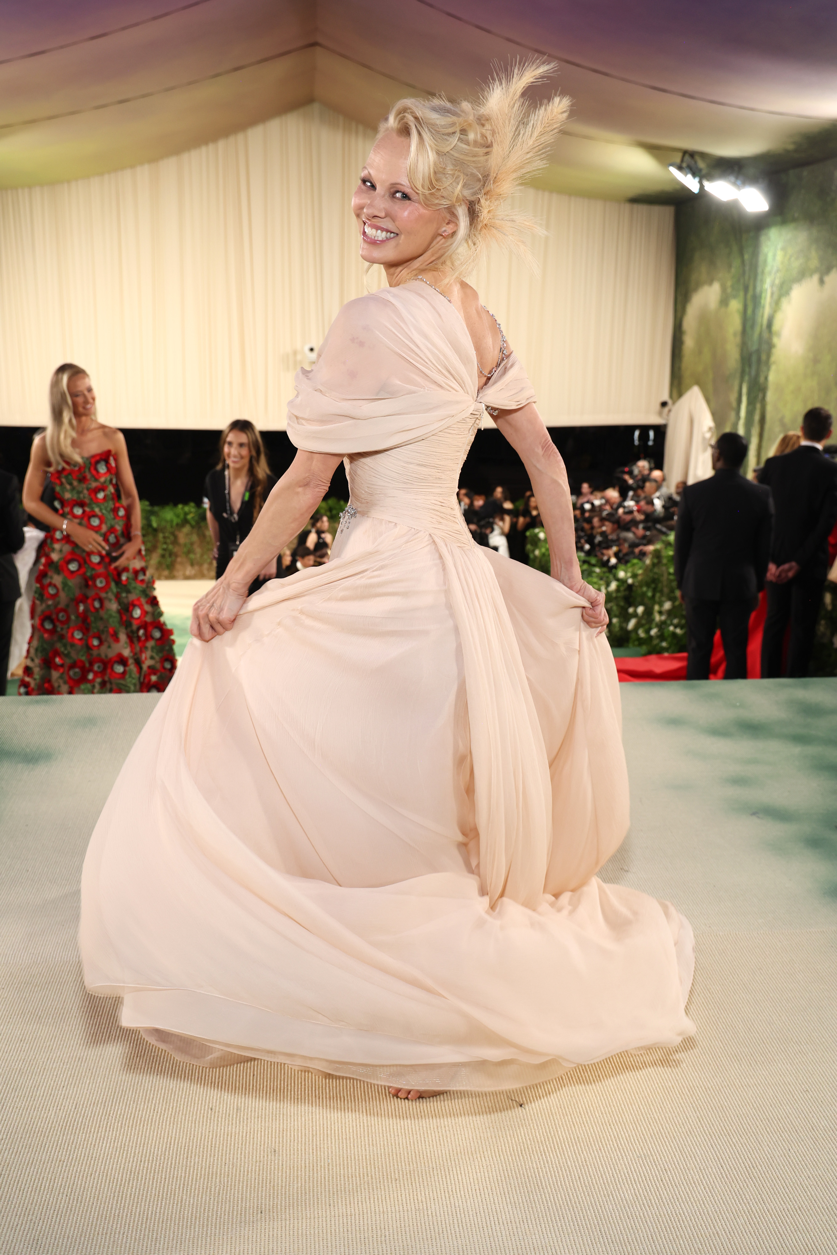 Pamela Anderson twirls in a nude colored gown at the Met Gala 2024