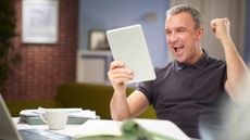 Mature man punching the air after saving money on an online quote