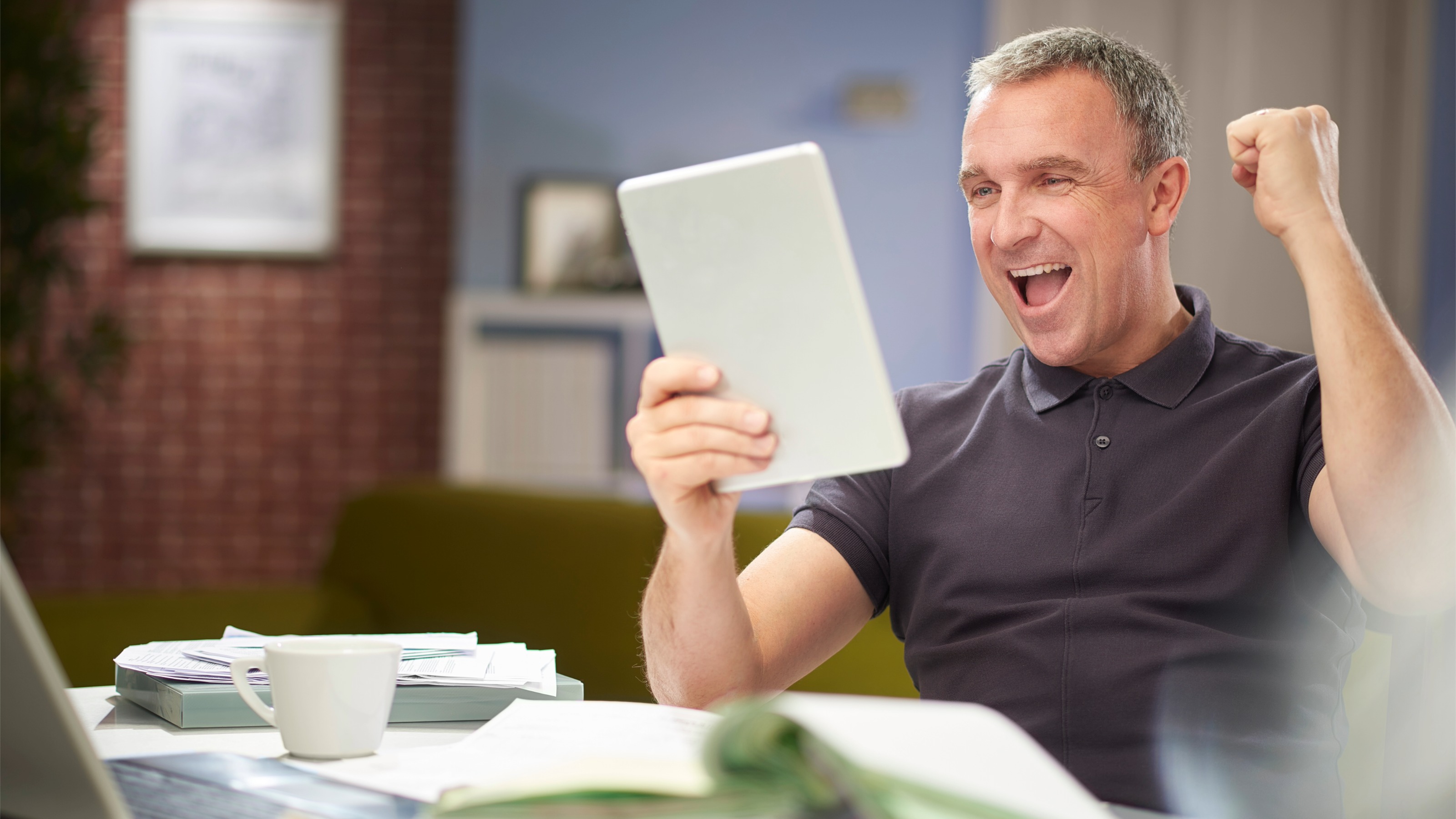Mature man punching the air after saving money on an online quote