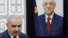 Mohammad Shtayyeh next to a portrait of President Mahmoud Abbas