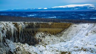 A giant crater in Siberia covered in snow and ice. 