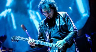 Tony Iommi is bathed in blue light as he plays with Sabbath in 2013.