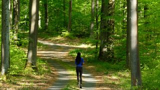 Woman running through a forest