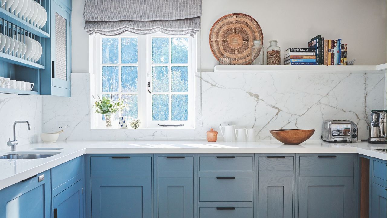  Kitchen with pale blue fitted cabinets, white worktop and walls and tiled floor and a faucet 