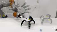 Robotic hand walking on a white table.