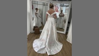 A woman in a wedding dress in front of a double mirror.
