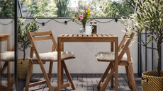 a bistro table on a porch with greenery surrounding the scene