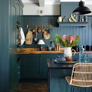 Blue panelled and painted kitchen cabinets and drawers, wooden worktop