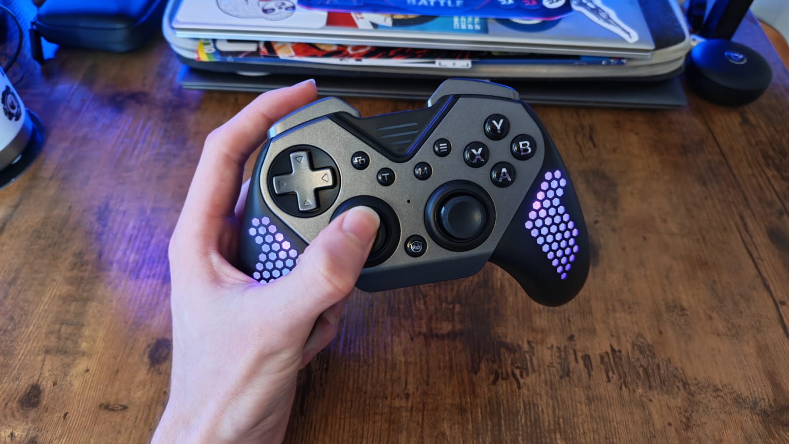 A reviewer holding the Nyxi Flexi controller with its pink lighting on