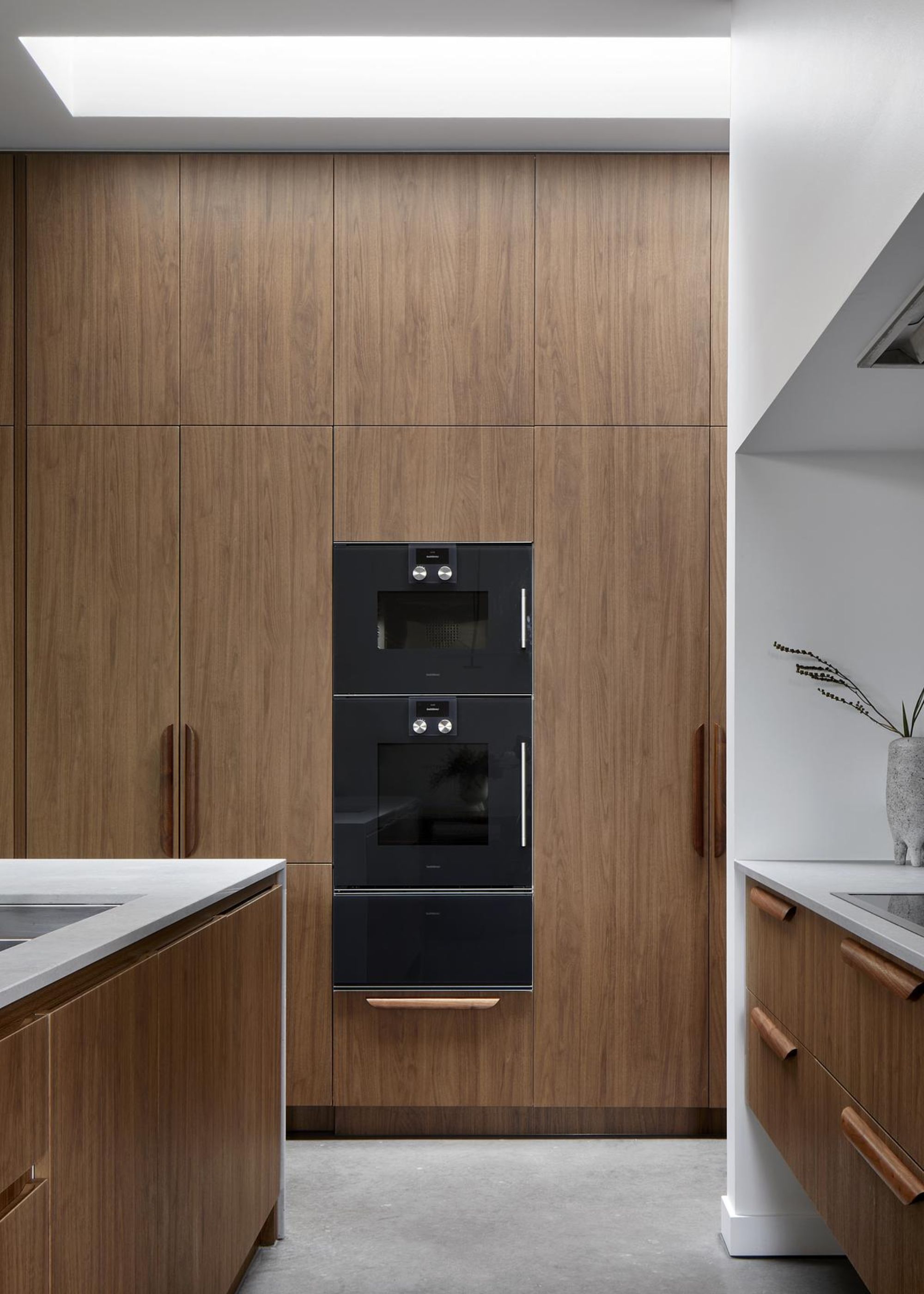 A kitchen with a microwave, oven and proving drawer stacked on top of one another
