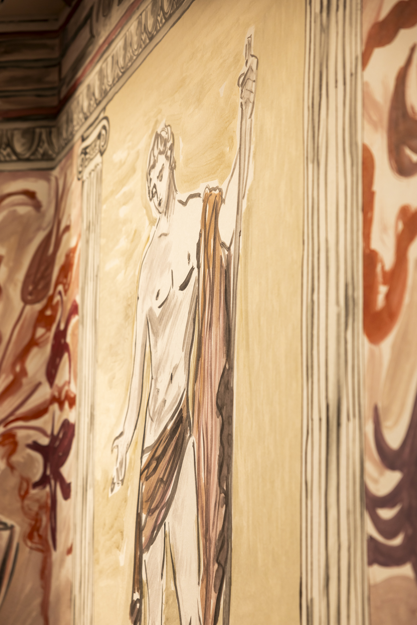 A close up of a trompe l'oeil wallpaper with columns and statues