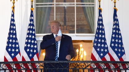 U.S. President Donald Trump removes his mask upon return to the White House from Walter Reed National Military Medical Center on Oct. 05, 2020, in Washington, D.C.