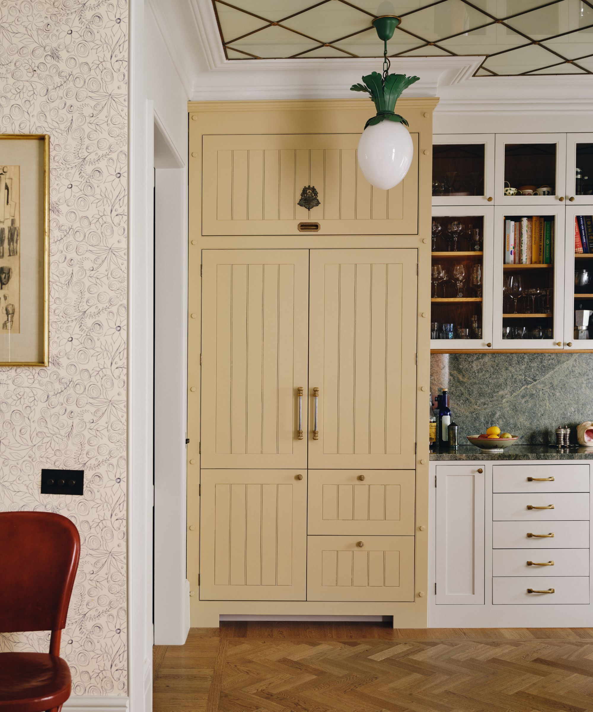 A kitchen larder painted in straw yellow paint