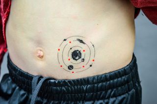 Space-inspired temporary tattoo on a child's stomach