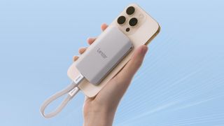 Lexar ES5 SSD attached to an iPhone being held in front of a blue backdrop