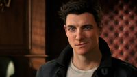 A male animated character with short, dark hair smirks confidently. He wears a black jacket over a white shirt, set against a warmly lit, leather-paneled wall.