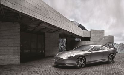 A silver sports car parked outside an angular, brick building