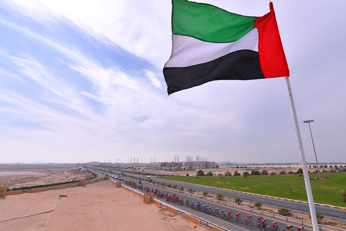 The UAE flag flies high above the peloton